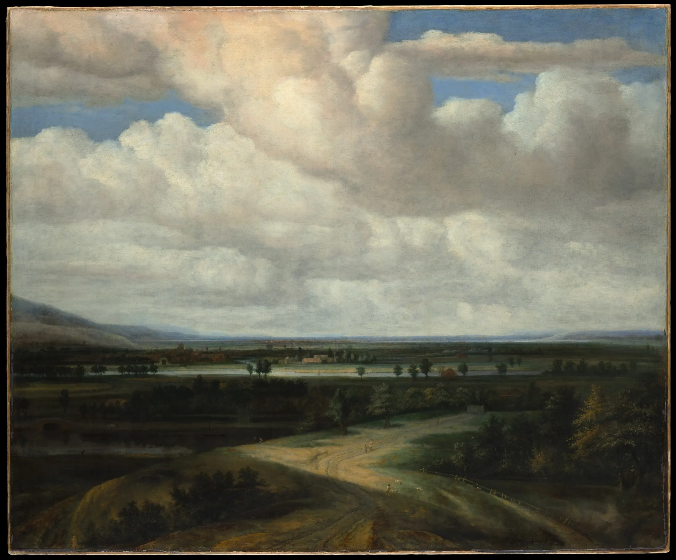A wide Dutch landscape under a tall sky full of clouds.